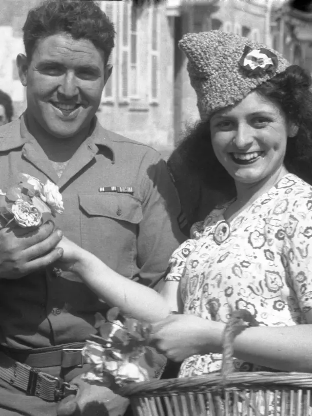 Une femme accueille un soldat américain avec des fleurs au Pouliguen, lors de la libération de la poche de Saint-Nazaire, le 11 mai 1945.
