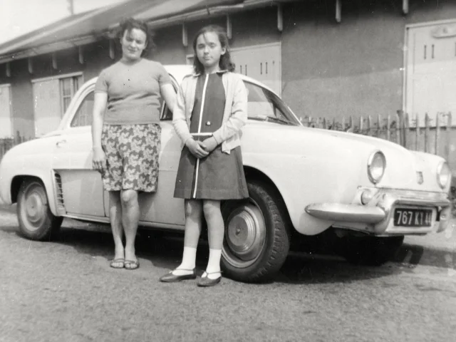 Une Femme Et Une Enfant Posent Appuyees A Une Renault Dauphine Devant Un Baraquement De Cite Provisoire Dans Les Annees 1950 Collection Lanuel Ecomusee